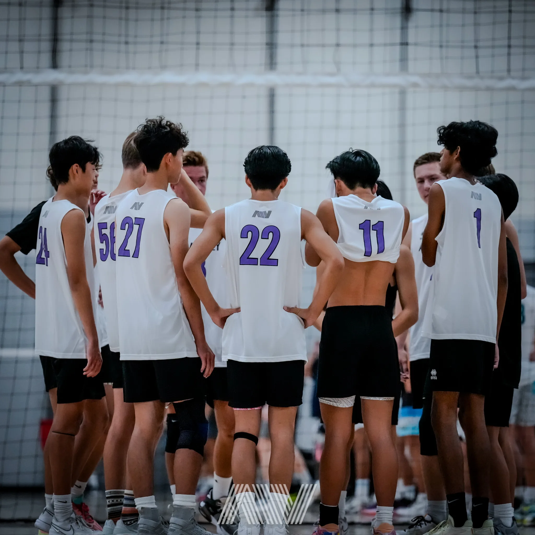 A4 boys volleyball team huddle inside the facility